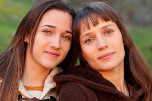 Nice sisters with blue eyes in a park