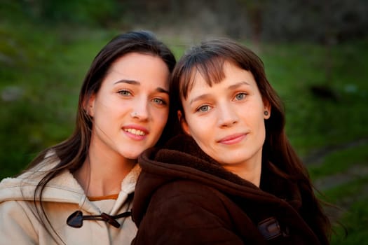 Nice sisters with blue eyes in a park