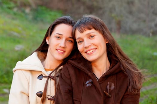 Nice sisters with blue eyes in a park