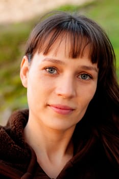 Beautiful brunette woman with blue eyes in the park