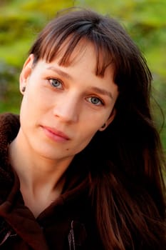 Beautiful brunette woman with blue eyes in the park