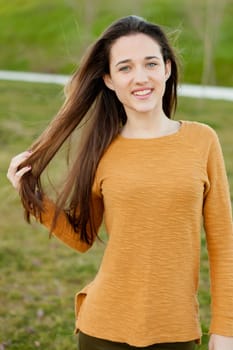 Outdoor portrait of beautiful happy teenager girl laughing while the wind moves her hair