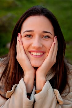 Smiling teen girl outside with a natural green of background