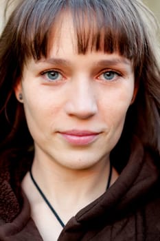 Beautiful brunette woman with blue eyes in the park