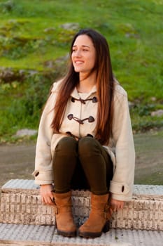 Pretty teenager girl sitting on the sidewalk in a park