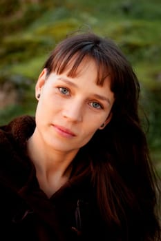 Beautiful brunette woman with blue eyes in the park