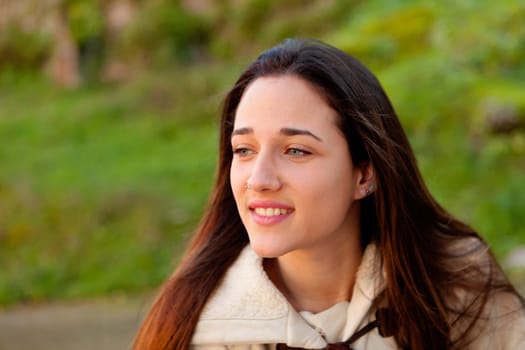 Smiling teen girl outside with a natural green of background