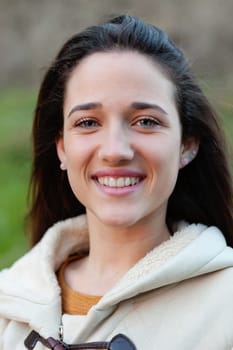 Smiling teen girl outside with a natural green of background