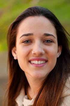 Smiling teen girl outside with a natural green of background