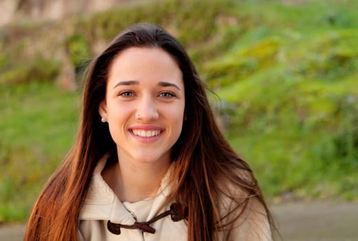 Smiling teen girl outside with a natural green of background