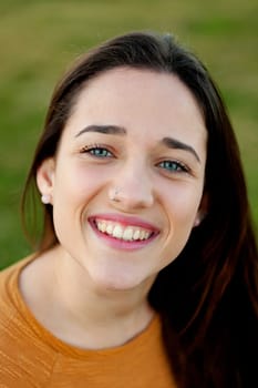 Outdoor portrait of beautiful happy teenager girl laughing with perfect teeth in field