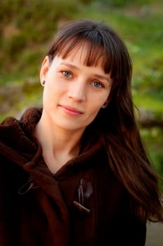 Beautiful brunette woman with blue eyes in the park