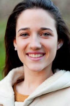 Smiling teen girl outside with a natural green of background