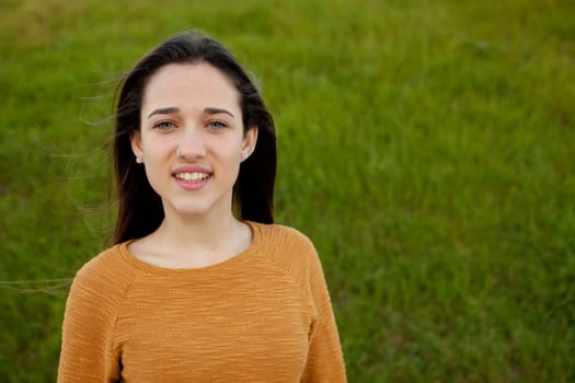 Outdoor portrait of beautiful happy teenager girl laughing with perfect teeth in field
