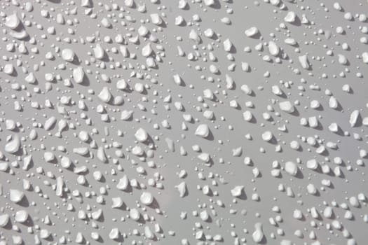 Water drops from rain over a white surface