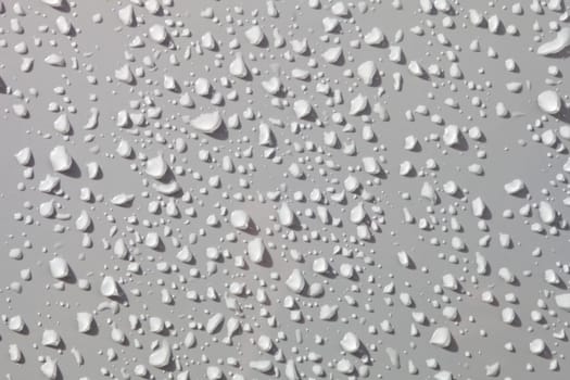 Water drops from rain over a white surface