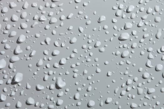 Water drops from rain over a white surface