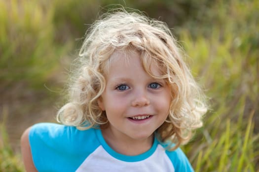 Small child with long blond hair enjoying of a sunny day