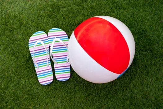 Flip-flops on the green grass of the pool