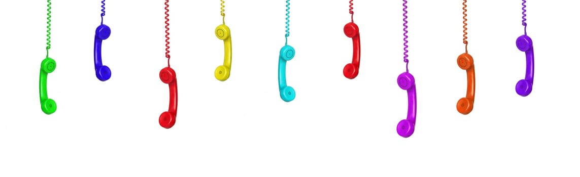 Row of old handsets hanging on white background