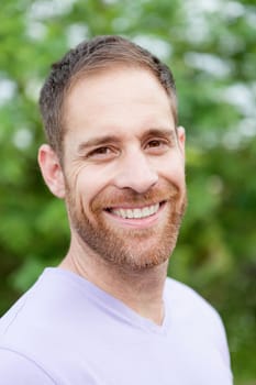Portrait of a casual bearded man with many plants of background