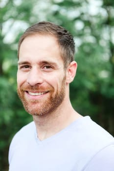 Portrait of a casual bearded man with many plants of background