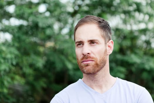 Portrait of a casual bearded man with many plants of background