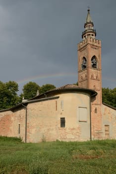 view of the apse side of Romanesque church  near the river, shot in bright light under a rainbow ..