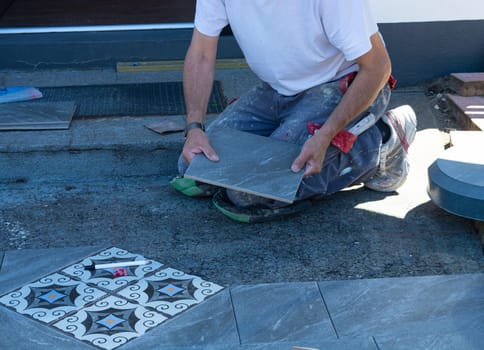 Laying ceramic floor tiles - man hands closeup