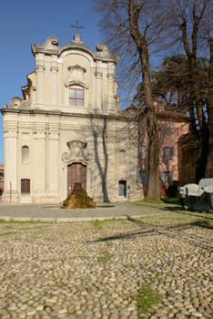 view of old church and cobble square in front of it, shot in bright winter light.