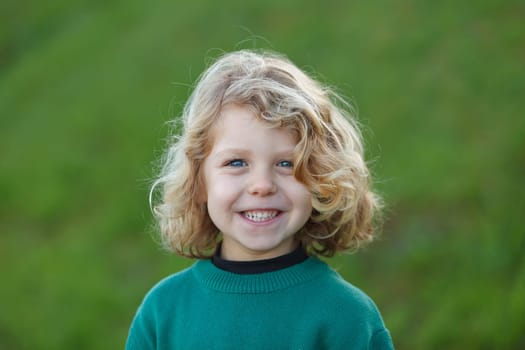 Small child with long blond hair enjoying of a sunny day