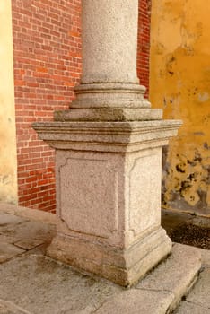decorated stone column pedestal of church facade at Morimondo Romanesque abbey, shot in bright winter light near Milan, Italy .