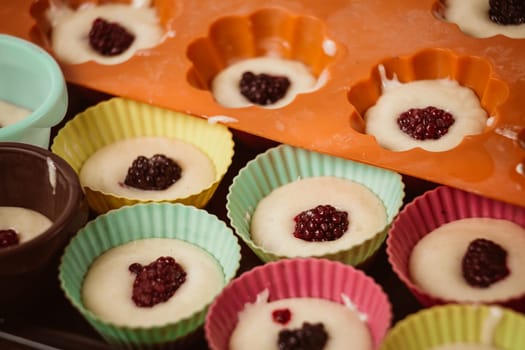 Rows of colorful cups. Muffins preparation at home.