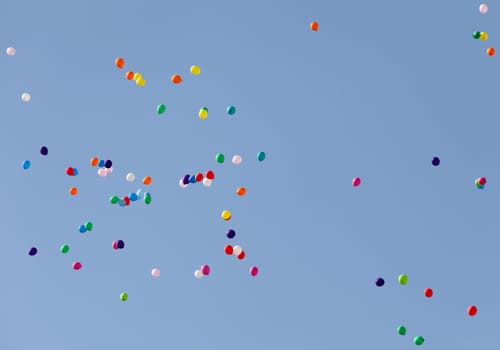 multi-colored balloons into the sky