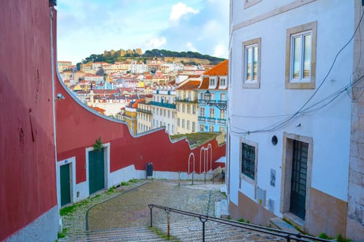 Empty stairs down the street and skyline of Lisbon Old Town with Lisbon Castle on a top of a hill. Portugal
