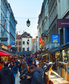 BRUSSELS, BELGIUM - OCTOBER 06, 2019: Crowd of people walking by Old Town shopping street of Brussels at twilight