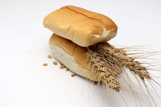 tasty and healthy bread and ripe wheat on white background