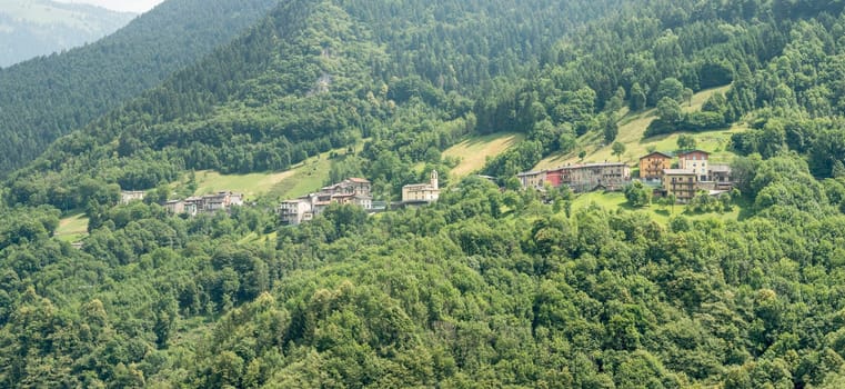 mountain green landscape with small village, shot in bright summer light at Azzone di Scalve, Bergamo, Orobie, Lombardy, Italy.