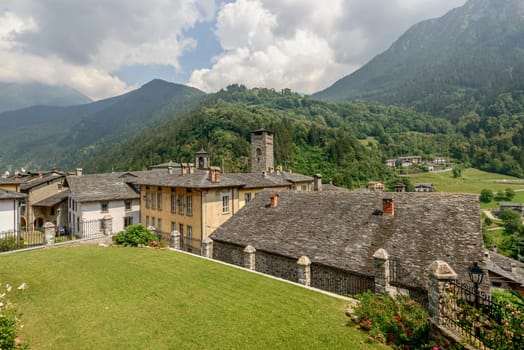 cityscape of historical village with old houses covered by slate roofs , shot in bright summer light at Gromo, Bergamo, Lombardy, Italy.