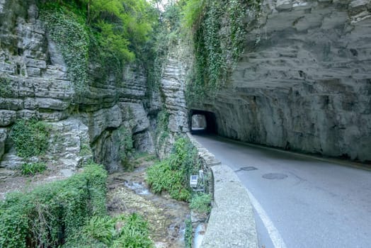 road and creek sneak at bottom of Brasa gorge, shot in bright fall light at Tremosine, Brescia, Italy.