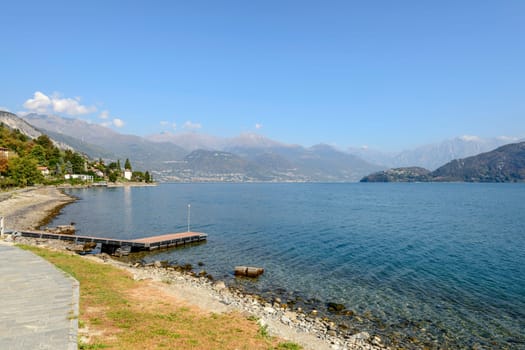 shore and landscape of green Como lake, shot toward east in bright fall light at Cremia, Como, Italy.