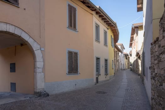 cityscape with bending historical street at touristic historical village on shore of Verbano lake, shot in bright winter light at Angera, Verbano, Varese, Lombardy, Italy.
