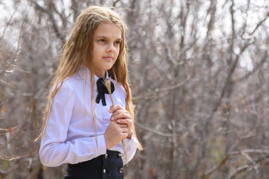 Portrait of a girl with dried wildflowers in her hands on a forest background