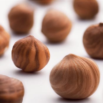 Hazelnuts scattered on a white background, whole, selective focus. The concept of healthy eating.