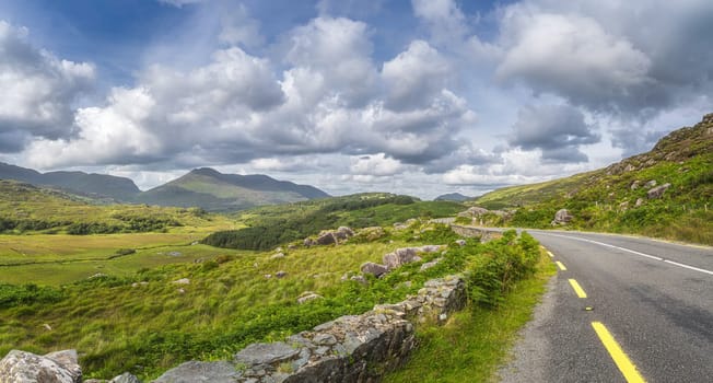 Winding road through Molls Gap with Owenreagh River valley, MacGillycuddys Reeks mountains and sheep farms, Wild Atlantic Way, Ring of Kerry Ireland