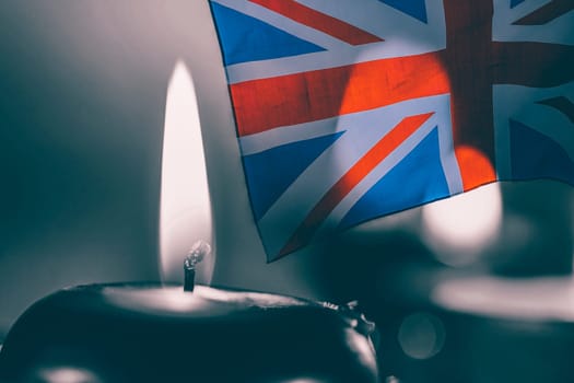 Burning candle and UK flag. The concept of mourning and sorrow in the country, UK national mourning