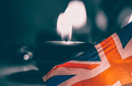 Burning candle and UK flag. The concept of mourning and sorrow in the country, UK national mourning