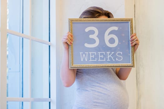 36 weeks of pregnancy, sign with text in woman arms