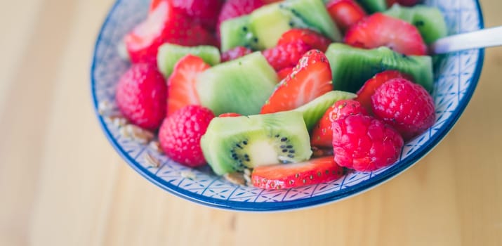 Close up of strawberries and kiwis in a ceramic bowl
