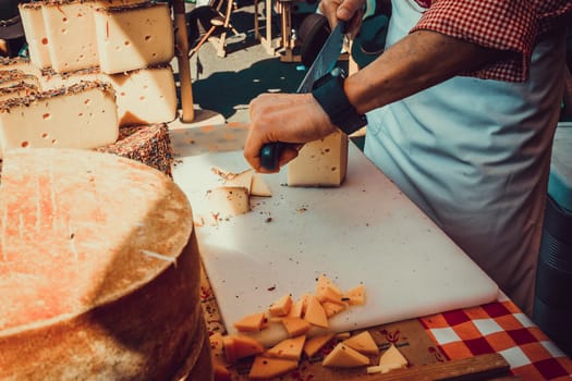 Worker slicing the cheese. Close up of Cutting cheese.
